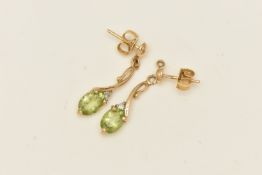 A PAIR OF 9CT YELLOW GOLD GEM SET DROP EARRINGS, AF earrings, oval cut peridot, accented with a