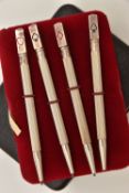 A CASED SET OF FOUR WHITE METAL BRIDGE PENCILS, each stamped 'Sterling Silver', with enamel card