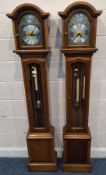 A PAIR OF TEMPUS FUGIT YEW WOOD CLOCKS, with an arched top, the glass door enclosing an 8-inch brass