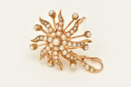 AN EARLY 20TH CENTURY BROOCH PENDANT, designed as a yellow metal starburst, set with seed pearls,