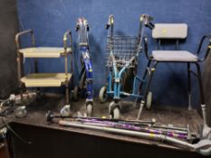 A COLLECTION OF MOBILITY AIDS including two rollaters, a stool, a trolley, a pair of crutches, and