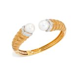 A cultured pearl and diamond torque bangle, the terminals set with a South Sea cultured pearl, ap...