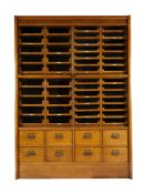 An English oak haberdashery cabinet, by E.Pollard & Co, first quarter 20th century, with four gla...