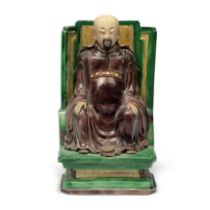 A Chinese famille verte on biscuit figure of Zhenwu Qing dynasty, Kangxi period Seated on a hig...