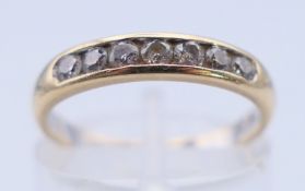 An 18 ct gold and diamond channel-set ring. Ring size L. 2.3 grammes total weight.