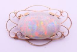 A 9 ct gold and opal brooch. 3.5 cm wide. 5.3 grammes total weight.