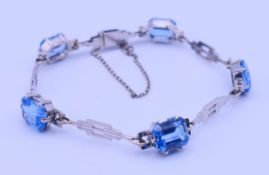 A 9 ct white gold and blue stone bracelet. 16 cm long 9.4 grammes total weight.