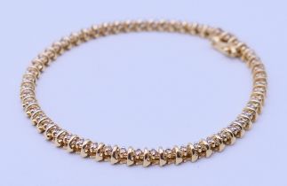 A 14 K gold and diamond tennis bracelet. 18 cm long. 11.2 grammes total weight.