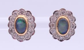A pair of unmarked gold, diamond and opal earrings. 1.25 cm high.