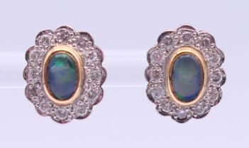 A pair of unmarked gold, diamond and opal earrings. 1.25 cm high.