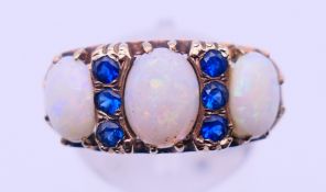 A 9 ct gold, opal and sapphire ring. Ring size Q. 4.8 grammes total weight.
