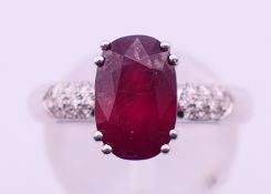 An 18 ct white gold ruby and diamond ring. Ring size M. 4.4 grammes total weight.