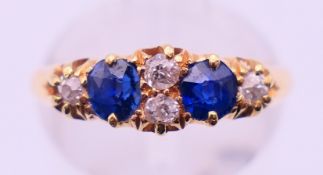 An 18 ct gold, diamond and sapphire ring. Ring size M. 2.9 grammes total weight.