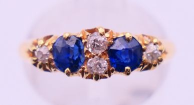 An 18 ct gold, diamond and sapphire ring. Ring size M. 2.9 grammes total weight.