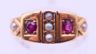 An 18 ct gold, ruby and seed pearl ring. Ring size M. 3.2 grammes total weight.