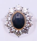 An 18 ct white gold, diamond and cabouchon sapphire cluster ring. Ring size O.