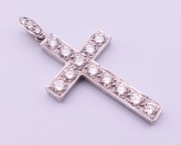 An unmarked white gold or platinum diamond set cross pendant. 4 cm high including suspension loop.