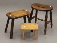 Two 19th century oak/elm stools and a 20th century elm stool. The largest 45 cm high.