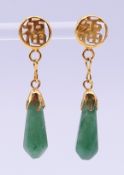 A pair of Chinese unmarked yellow metal mounted jade earrings. 4 cm high.