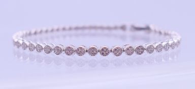 A silver cubic zirconia line bracelet. 19 cm long.