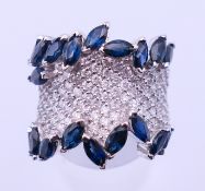 A Modernist 14 ct white gold, sapphire and diamond ring. Ring size L.