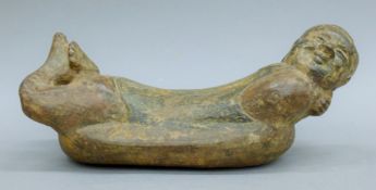 A Chinese iron headrest formed as a male figure. 35 cm long.