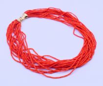 A multi-strand coral bead necklace with an 18 ct gold clasp. 46 cm long.