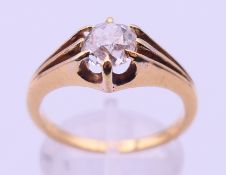 An unmarked gold and diamond solitaire ring. The stone spreading top approximately just over 1 ct.