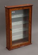 A glazed wall-hanging display cabinet. 56 cm wide x 84 cm high.