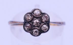 An 18 ct diamond daisy cluster ring. Ring size O/P.