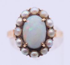 An unmarked gold, opal and seed pearl ring. Ring size M/N. 4 grammes total weight.