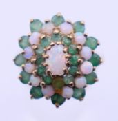 A 9 ct gold, opal and emerald cluster ring. Ring size O/P. 4.9 grammes total weight.
