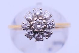 A gold and diamond daisy ring. Ring size M. 3.3 grammes total weight.