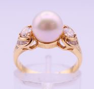 An 18 ct gold, diamond and pearl ring. Ring size L/M. 3.9 grammes total weight.