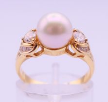 An 18 ct gold, diamond and pearl ring. Ring size L/M. 3.9 grammes total weight.