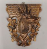 A 19th century Black Forest carving of a stag's head fitted to a carved shield. 38 cm high.