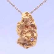 A diamond set 22 ct gold nugget pendant on an unmarked chain. The pendant 4 cm high. 46.