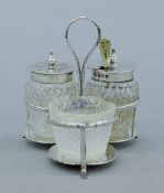 A small silver cruet stand with silver-plates salt spoon. 7.5 cm high. 43.