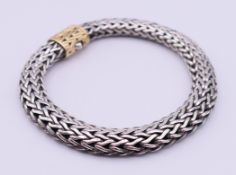 A silver and 18 K gold bracelet. 22.5 cm long, 1 cm high. 73.8 grammes total weight.