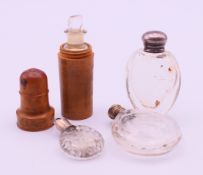 Three silver-topped small scent bottles and a box wood cased scent bottle. The latter 6.5 cm high.