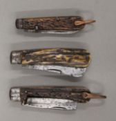 Three vintage antler-handled folding knives. The largest 12 cm long closed.