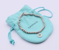 A Tiffany & Co silver mini heart tag bead bracelet, in Tiffany bag. 18 cm long.