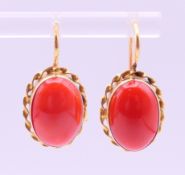 A pair of 18 ct gold and coral earrings. 1.7 cm high excluding suspension loop.
