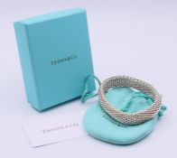 A boxed Tiffany & Co silver bracelet. 1.5 cm high, 6 cm internal diameter. 54.3 grammes.