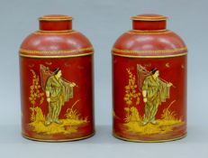 A pair of red toleware tea canisters. Each 36 cm high.