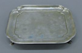 A silver lobed rectangular salver with presentation inscriptions. 25 cm wide. 493.7 grammes.