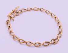 An 18 ct gold watch chain. Approximately 38 cm long. 57.4 grammes.