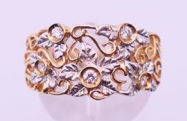 A 14 K gold and diamond florally-pierced ring. Ring size O/P. 4.7 grammes total weight.