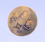 A boxed Garrard silver gilt golf ball marker. 1.5 cm diameter.