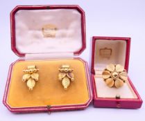 A boxed unmarked gold Cartier ring and a pair of matching boxed unmarked gold Cartier earrings.